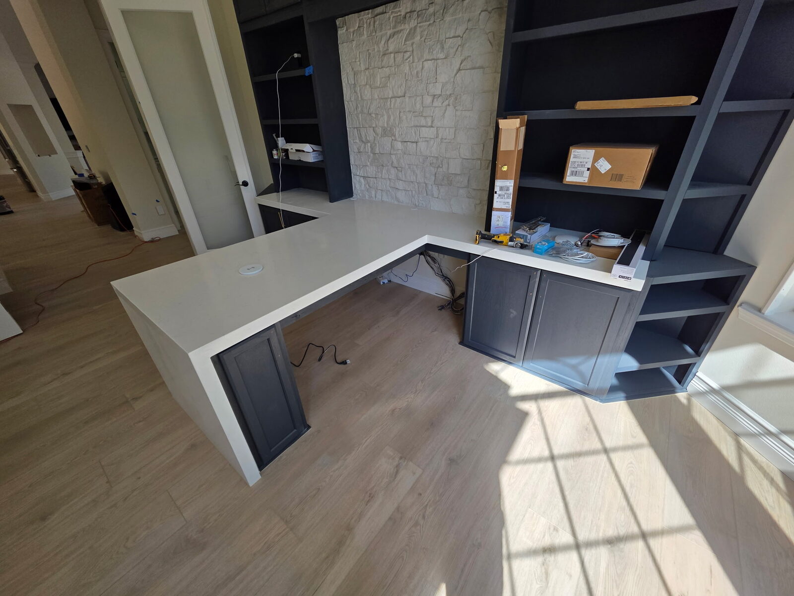 Interior remodel featuring new wood-look flooring and a built-in work area.