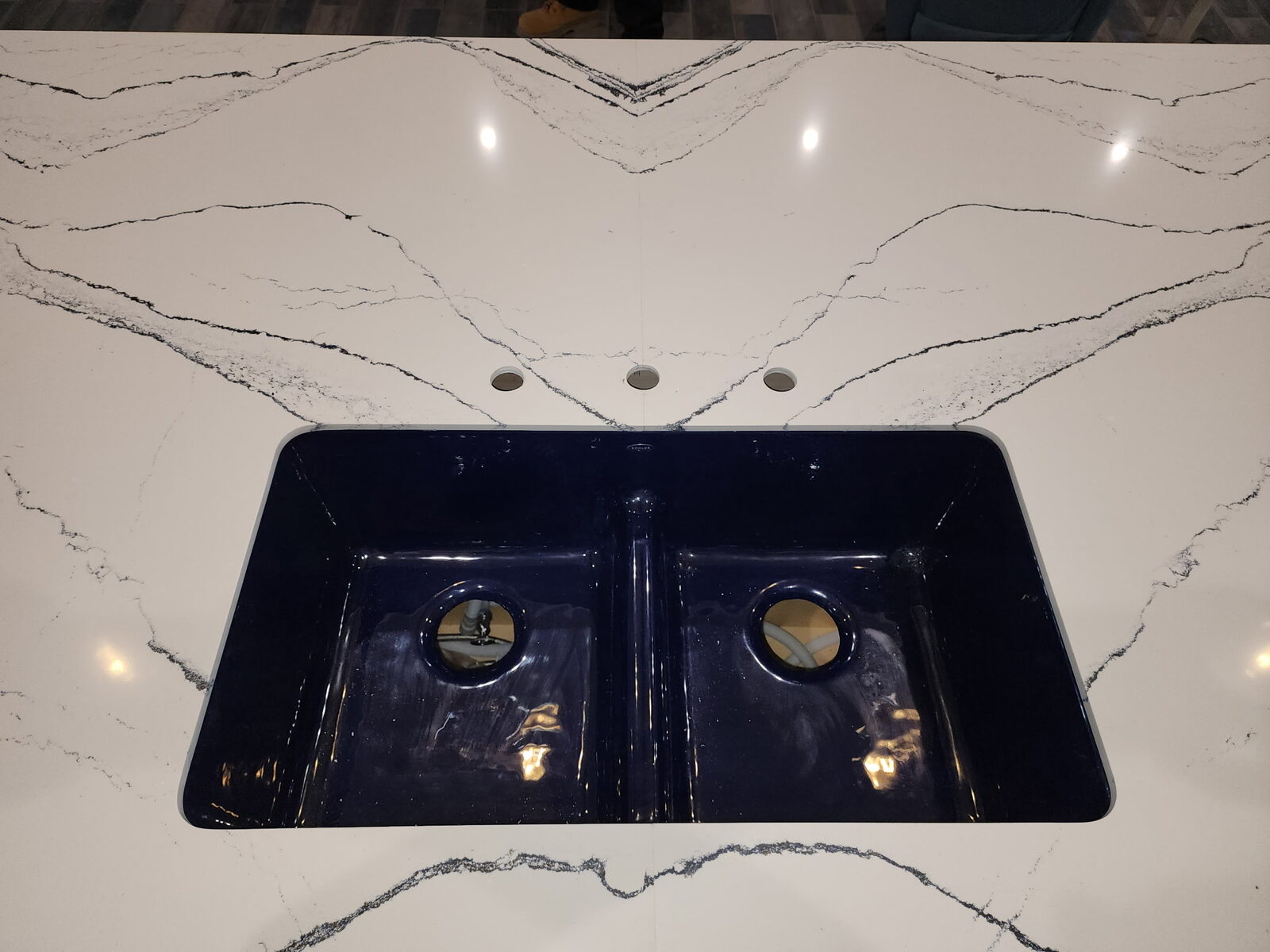 Bookmatched white countertop detail with a dark undermount sink and dramatic veining.